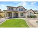 Attractive two-story home with a covered front porch, manicured lawn, and neutral colored stucco at 21104 W Sage Hill Rd, Buckeye, AZ 85396