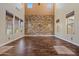 Spacious living room features high ceilings, hardwood floors, and a distinctive stone accent wall at 21104 W Sage Hill Rd, Buckeye, AZ 85396
