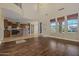 Well-lit living room featuring hardwood floors, a kitchen view, and large windows at 21104 W Sage Hill Rd, Buckeye, AZ 85396