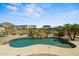 Backyard swimming pool with rock waterfall feature and tropical landscaping with neighborhood view at 21104 W Sage Hill Rd, Buckeye, AZ 85396