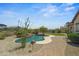 Inviting backyard pool with stone features, lush landscaping, and charming brick walkway at 21104 W Sage Hill Rd, Buckeye, AZ 85396