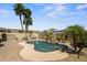 Spacious backyard featuring a sparkling pool, mature trees, desert landscaping, and lovely mountain views at 21104 W Sage Hill Rd, Buckeye, AZ 85396