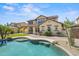 Gorgeous backyard featuring a sparkling pool, mature trees, covered patio, and lush lawn at 21104 W Sage Hill Rd, Buckeye, AZ 85396