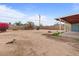 Sunny backyard with desert landscaping, block fence, patio, and mature trees offering shade and privacy at 2144 W 1St Pl, Mesa, AZ 85201