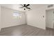 A modern bedroom with a ceiling fan, window, and new flooring at 2144 W 1St Pl, Mesa, AZ 85201