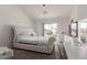 Bedroom with a queen-sized white tufted headboard, dresser, and sliding glass door to the backyard at 21972 W Pima St, Buckeye, AZ 85326