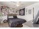Fun bedroom features a cozy bed, ceiling fan, and a wall decorated with skate culture memorabilia at 21972 W Pima St, Buckeye, AZ 85326