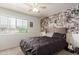 Bright bedroom with a comfortable bed, window with blinds, and a wall adorned with collage art at 21972 W Pima St, Buckeye, AZ 85326