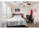 Comfortable bedroom with natural light, ceiling fan, and personal touches at 21972 W Pima St, Buckeye, AZ 85326