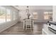 Bright dining room with wood floors, white trim, a pendant light, and large windows for ample natural light at 21972 W Pima St, Buckeye, AZ 85326