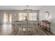 Bright dining room with wood-look flooring, a modern chandelier, and backyard views at 21972 W Pima St, Buckeye, AZ 85326