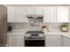 Close-up of kitchen with stainless steel appliances, white cabinets, and modern countertops at 21972 W Pima St, Buckeye, AZ 85326
