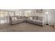 Spacious living room featuring a comfortable gray sectional sofa and neutral décor at 21972 W Pima St, Buckeye, AZ 85326