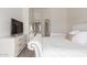 Bright main bedroom featuring a queen-sized bed, white tufted headboard, dresser, and en-suite bathroom at 21972 W Pima St, Buckeye, AZ 85326