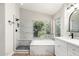 Bathroom featuring a walk-in shower, tub, and double vanity at 236 W Calle Monte Vista Dr, Tempe, AZ 85284