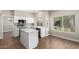Modern kitchen with white cabinets, a center island, stainless steel appliances, and wood flooring at 236 W Calle Monte Vista Dr, Tempe, AZ 85284