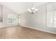 Bright room with wood floors, light walls, vaulted ceilings, large windows, and a modern chandelier at 236 W Calle Monte Vista Dr, Tempe, AZ 85284
