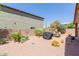 A spacious backyard with desert landscaping, a grill, and an outdoor dining area at 28834 N Spur Dr, San Tan Valley, AZ 85143