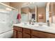 Well-lit bathroom features a dual sink vanity, a large mirror, and a shower over tub with glass doors at 28834 N Spur Dr, San Tan Valley, AZ 85143