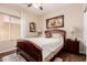 Cozy bedroom features a queen bed, wood floors, and a window with blinds for privacy at 28834 N Spur Dr, San Tan Valley, AZ 85143