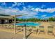 A serene community pool is surrounded by lounge chairs and lush landscaping for relaxation and recreation at 28834 N Spur Dr, San Tan Valley, AZ 85143