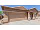 Exterior view of a single-story house with neutral stucco, attached two-car garage, and xeriscaped front yard at 28834 N Spur Dr, San Tan Valley, AZ 85143