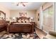 Spacious bedroom featuring wood floors, natural light, a ceiling fan and a comfortable king size bed at 28834 N Spur Dr, San Tan Valley, AZ 85143