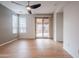 Bright living room with wood floors, fan, and sliding glass doors to an outdoor patio at 28837 N 127Th Ave, Peoria, AZ 85383