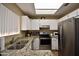 Modern kitchen featuring stainless steel appliances, granite countertops, and white cabinets at 2941 N Oregon St # 12, Chandler, AZ 85225
