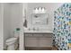 Well-lit bathroom features a white countertop vanity, decorative mirror, and cactus-themed shower curtain at 3175 E Merrill Ave, Gilbert, AZ 85234