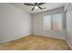 Empty bedroom featuring neutral wall, neutral tile flooring, and natural light from a large window at 3175 E Merrill Ave, Gilbert, AZ 85234