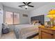 Cozy bedroom with a patterned comforter, ceiling fan, and a window providing natural light at 3175 E Merrill Ave, Gilbert, AZ 85234