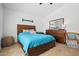 Inviting bedroom featuring a neutral tile flooring, ceiling fan, modern dresser, and a comfortable bed at 3175 E Merrill Ave, Gilbert, AZ 85234