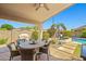 Covered patio features a dining set overlooking a private backyard with lush landscaping and pool at 3175 E Merrill Ave, Gilbert, AZ 85234
