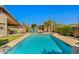 Inviting backyard with a sparkling swimming pool, lounge chairs, and lush landscaping, creating a private oasis at 3175 E Merrill Ave, Gilbert, AZ 85234