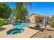 Beautiful backyard pool and spa, showcasing lounge chairs, lush landscaping, and a covered patio for outdoor enjoyment at 3175 E Merrill Ave, Gilbert, AZ 85234