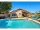 Sparkling backyard pool area featuring a patio, lounge chairs, lush greenery, and shaded seating for relaxation at 3175 E Merrill Ave, Gilbert, AZ 85234