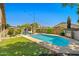 Backyard pool area with a turquoise pool, lounge chairs, and outdoor lighting, perfect for relaxing at 3175 E Merrill Ave, Gilbert, AZ 85234