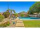 Inviting backyard swimming pool with lounge chairs and umbrella, surrounded by beautiful landscaping at 3175 E Merrill Ave, Gilbert, AZ 85234