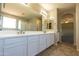 Bathroom featuring a double vanity with white cabinets, a large mirror, and tiled floors at 3796 E Rakestraw Ln, Gilbert, AZ 85298