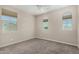 Empty bedroom features neutral carpet, a ceiling fan, and three windows offering natural light at 3796 E Rakestraw Ln, Gilbert, AZ 85298