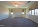 Spacious carpeted bonus room featuring multiple windows, blinds, and a ceiling fan at 3796 E Rakestraw Ln, Gilbert, AZ 85298