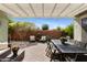 Charming backyard patio with brick pavers, a pergola, outdoor seating, and dining furniture with beautiful landscaping at 3881 E Galveston St, Gilbert, AZ 85295
