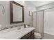 A bathroom features a vanity with a decorative mirror and a shower over a bathtub at 3881 E Galveston St, Gilbert, AZ 85295