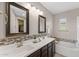 Stylish bathroom featuring dual sinks, dark wood cabinetry, and a combination tub and shower at 3881 E Galveston St, Gilbert, AZ 85295