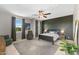 Spacious bedroom with natural light, featuring a ceiling fan, dark accent wall, and cozy furniture at 3881 E Galveston St, Gilbert, AZ 85295
