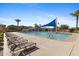 A community pool invites relaxation with its lounge chairs, umbrellas, and sparkling water on a sunny day at 3881 E Galveston St, Gilbert, AZ 85295