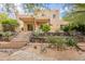This two-story home boasts a covered patio, stone stairs, desert landscaping, and a view of the natural terrain at 39017 N Habitat Cir, Cave Creek, AZ 85331