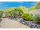 Beautifully landscaped backyard garden with stone accents, desert plants, and a charming pathway at 39017 N Habitat Cir, Cave Creek, AZ 85331