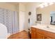 Bright bathroom with white cabinets, tile floor and tub-shower combo with a blue patterned curtain at 39017 N Habitat Cir, Cave Creek, AZ 85331